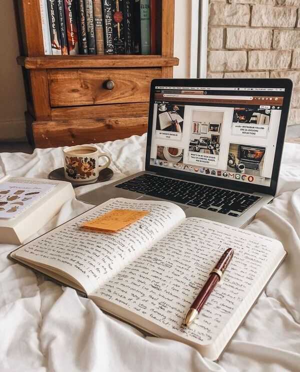 Laptop y libreta en una mesa con luz suave