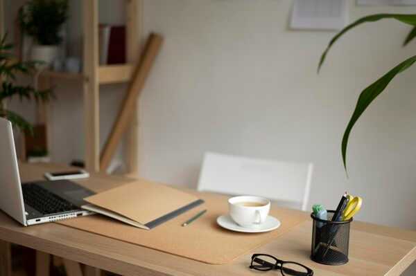 Escritorio con cuadernos, café y luz natural